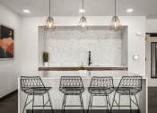 Thumbnail 30 of 61 - a kitchen with four bar stools in front of a white counter and a wall