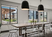 Thumbnail 27 of 61 - a dining room with a wooden table and chairs and large windows