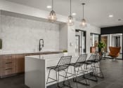 Thumbnail 36 of 61 - the kitchen has a large island with bar stools and a row of chairs