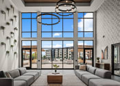 Thumbnail 34 of 61 - a living room with large windows and a couch and a table