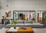 Thumbnail 37 of 61 - a living room with a gray couch and a coffee table