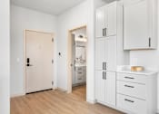 Thumbnail 43 of 53 - A kitchen with white cabinets and a wooden floor.