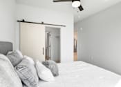 Thumbnail 50 of 53 - A bedroom with a bed, pillows, and a sliding door.