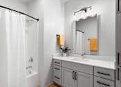 Thumbnail 42 of 53 - A white bathroom with a white tub and sink.