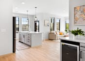 Thumbnail 36 of 53 - A modern kitchen with a large island and a dining area in the background.