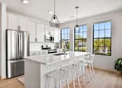 Thumbnail 49 of 53 - A modern kitchen with white cabinets and a large island.