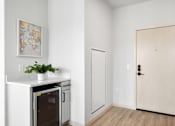 Thumbnail 51 of 53 - A kitchen with a fridge, a plant, and a picture on the wall.