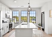 Thumbnail 45 of 53 - A modern kitchen with white cabinets and a large island.