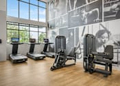 Thumbnail 16 of 26 - A gym with treadmills, exercise bikes and a wall of motivational posters.