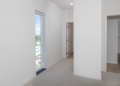 Thumbnail 18 of 27 - an empty room with a door to a hallway and a closet at Riverhouse Apartments, Fargo, North Dakota 58102