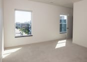 Thumbnail 16 of 27 - an empty living room with two windows and a city view at Riverhouse Apartments, Fargo, ND