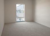 Thumbnail 14 of 27 - an empty room with a door to a balcony at Riverhouse Apartments, Fargo
