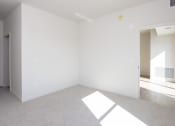 Thumbnail 21 of 27 - an empty living room with white walls and carpet at Riverhouse Apartments, North Dakota
