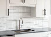 Thumbnail 5 of 17 - Contemporary kitchen sink and tile backsplash at The Avery - Residential Apartments, Fargo, ND
