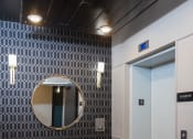 Thumbnail 34 of 50 - a seating area with a mirror and a bench in front of a door  at Dillard Apartments, Fargo, North Dakota, 58102