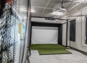 Thumbnail 25 of 27 - a batting cage in a gym with a green carpet at Riverhouse Apartments, Fargo