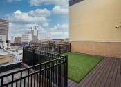 Thumbnail 28 of 50 - a balcony with green turf and a view of the city at Dillard Apartments, Fargo, North Dakota 58102