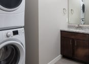 Thumbnail 36 of 37 - a bathroom with a washer and dryer and a sink  at RoCo Apartments, Fargo, ND 58102