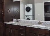 Thumbnail 23 of 37 - a bathroom with a sink and a washer and dryer  at RoCo Apartments, Fargo, ND 58102
