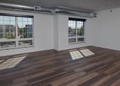 Thumbnail 51 of 84 - an empty room with hardwood floors and large windows at The Landing at 1001 NP, Fargo, ND 58102