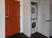 Thumbnail 56 of 84 - a door is open to a laundry room with a washer and dryer at The Landing at 1001 NP, Fargo, North Dakota 58102