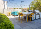 Thumbnail 66 of 84 - a patio with a table and chairs and a grill at The Landing at 1001 NP, Fargo, ND 58102