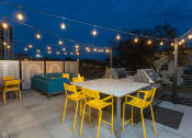 Thumbnail 83 of 84 - a rooftop deck with a dining table and yellow chairs at The Landing at 1001 NP, Fargo, ND 58102