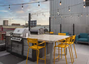Thumbnail 82 of 84 - a patio with a table and chairs and a grill at The Landing at 1001 NP, Fargo, ND, 58102