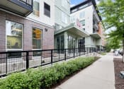 Thumbnail 29 of 86 - a sidewalk in front of a building with a black fence