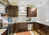 Thumbnail 4 of 86 - a kitchen with wooden cabinets and stainless steel appliances