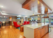 Thumbnail 17 of 86 - a large kitchen with a bar and a living room with a fireplace