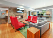 Thumbnail 18 of 86 - a living room with red chairs and a fireplace