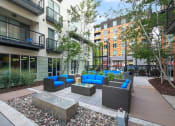 Thumbnail 23 of 86 - a courtyard with couches and a fire pit in front of a building