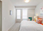 Thumbnail 36 of 86 - a bedroom with a bed and a door to a bathroom