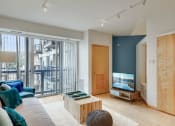 Thumbnail 6 of 86 - a living room with a couch and a tv and a balcony