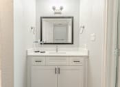 Thumbnail 37 of 42 - A bathroom vanity with a mirror above it.