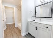 Thumbnail 40 of 42 - A bathroom with a white vanity and a mirror.