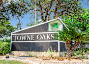 Thumbnail 1 of 11 - A sign that says "Towne Oaks" is in front of a tree.