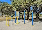 Thumbnail 3 of 7 - A blue and yellow outdoor gym equipment set up in a park.