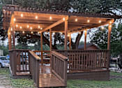 Thumbnail 16 of 19 - Shaded community gazebo with seating at Sierra Ranch Apartments in San Antonio, TX.