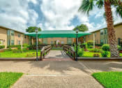 Thumbnail 1 of 5 - a covered walkway with a bridge in front of an apartment building