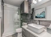Thumbnail 4 of 30 - Modern bathroom with sleek tile design and large vanity at Reserve on Abrams