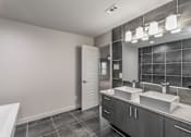 Thumbnail 25 of 30 - Modern bathroom with sleek tile design and large vanity at Reserve on Abrams