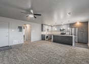 Thumbnail 30 of 30 - Modern open-concept living room with ceiling fan and wood-style floors at Reserve on Abrams Dallas