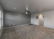 Thumbnail 29 of 30 - Modern open-concept living room with ceiling fan and wood-style floors at Reserve on Abrams Dallas