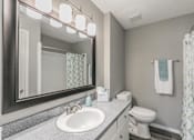 Thumbnail 13 of 17 - Bathroom with wide mirror, vanity lighting, and updated fixtures