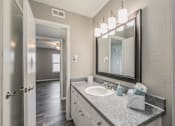 Thumbnail 12 of 17 - Bathroom with wide mirror, vanity lighting, and updated fixtures