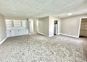 Thumbnail 2 of 13 - Large living room with grey carpet and bright natural light at Greenbriar Place 55+ Senior Apartments in Corpus Christi.