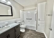 Thumbnail 6 of 13 - Bathroom with shower, toilet, and sink at Greenbriar Place 55+ Senior Apartments in Corpus Christi.