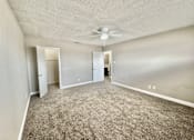 Thumbnail 4 of 13 - Bedroom with ceiling fan and carpet flooring at Greenbriar Place 55+ Apartments in Corpus Christi.